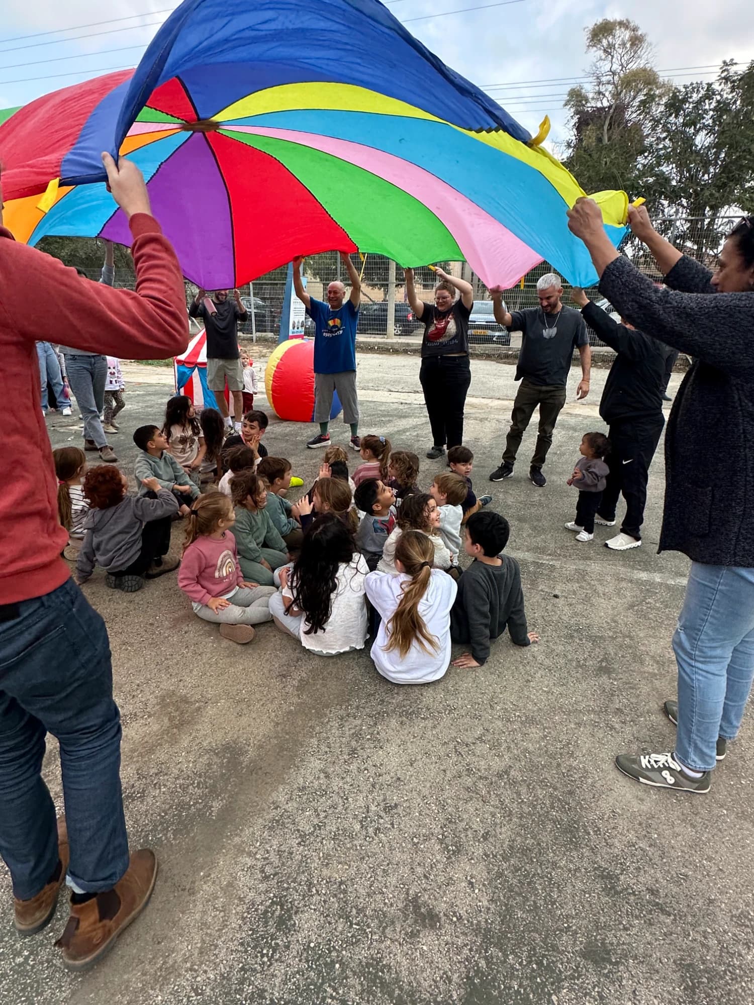 ילדים משחקים במצנח צבעוני ענק בהפעלה ליום הולדת של נוני אירועים