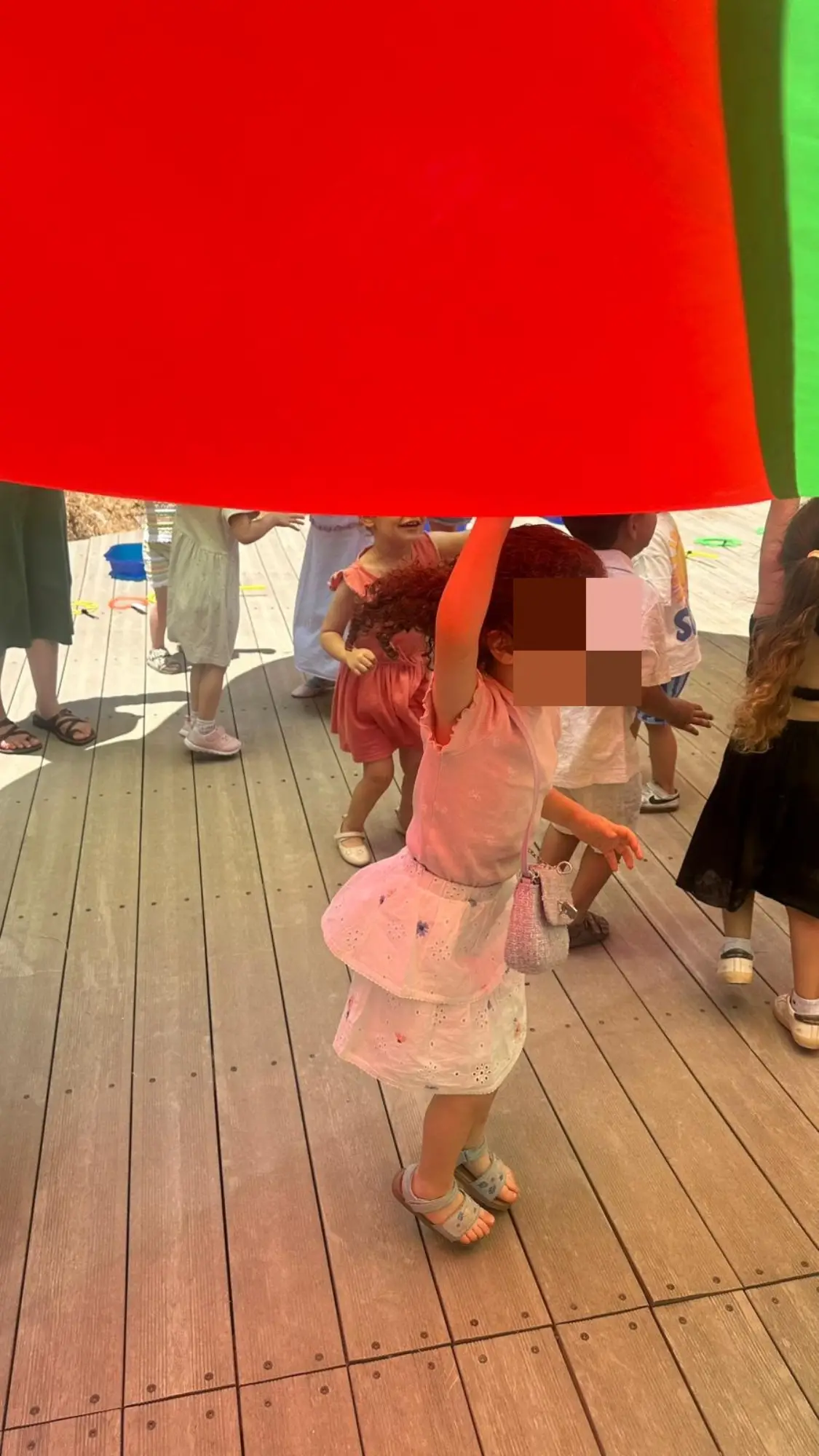 ילדה קטנה מתחת למצנח אדום בהפעלה של נוני אירועים